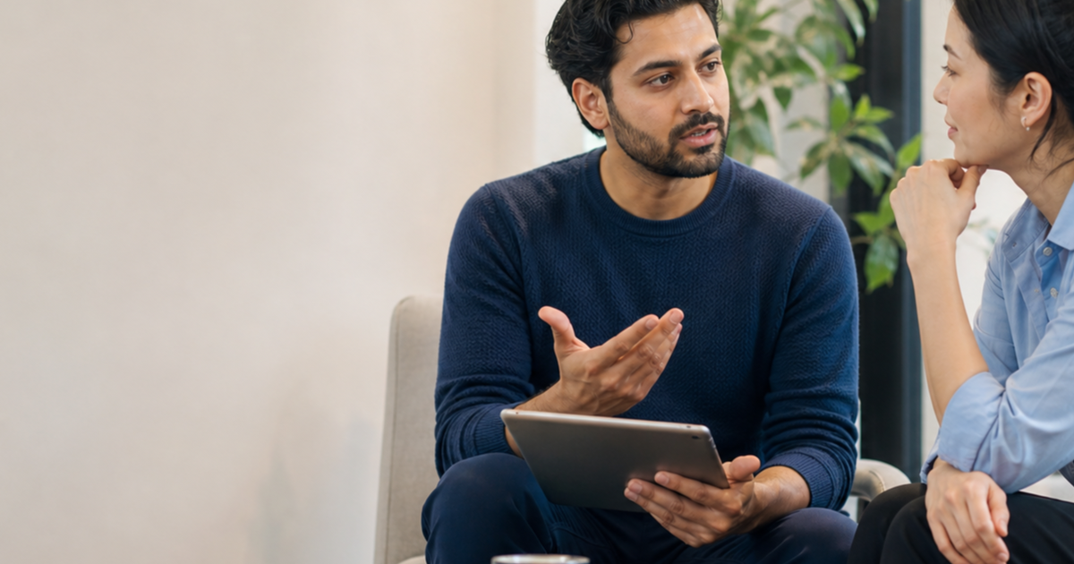 Two adults discussing an emotional misunderstanding with notes on a tablet